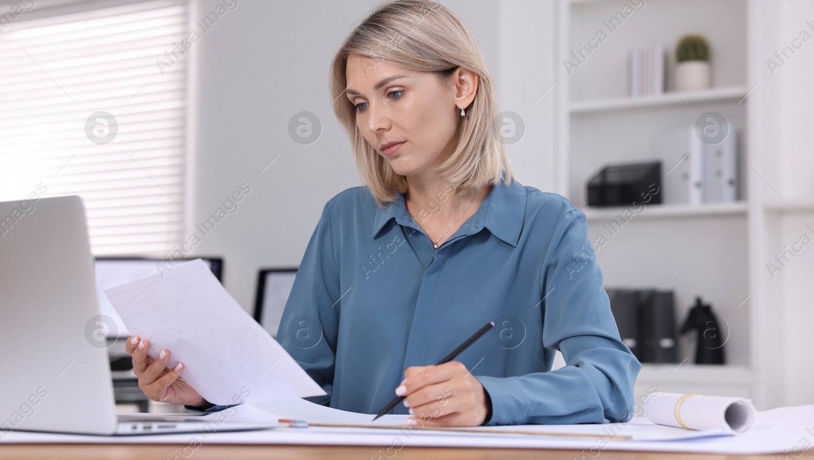 Photo of Architect making engineering drawing at table in office