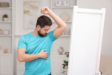 Photo of Handsome man after using deodorant at home