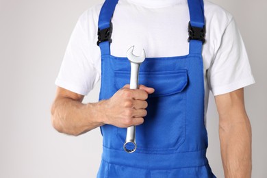 Photo of Auto mechanic with wrench on light grey background, closeup