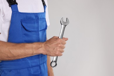 Photo of Auto mechanic with wrench on light grey background, closeup. Space for text