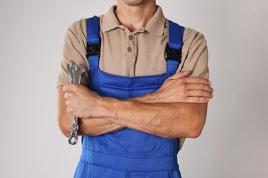 Photo of Auto mechanic with wrenches on light grey background, closeup