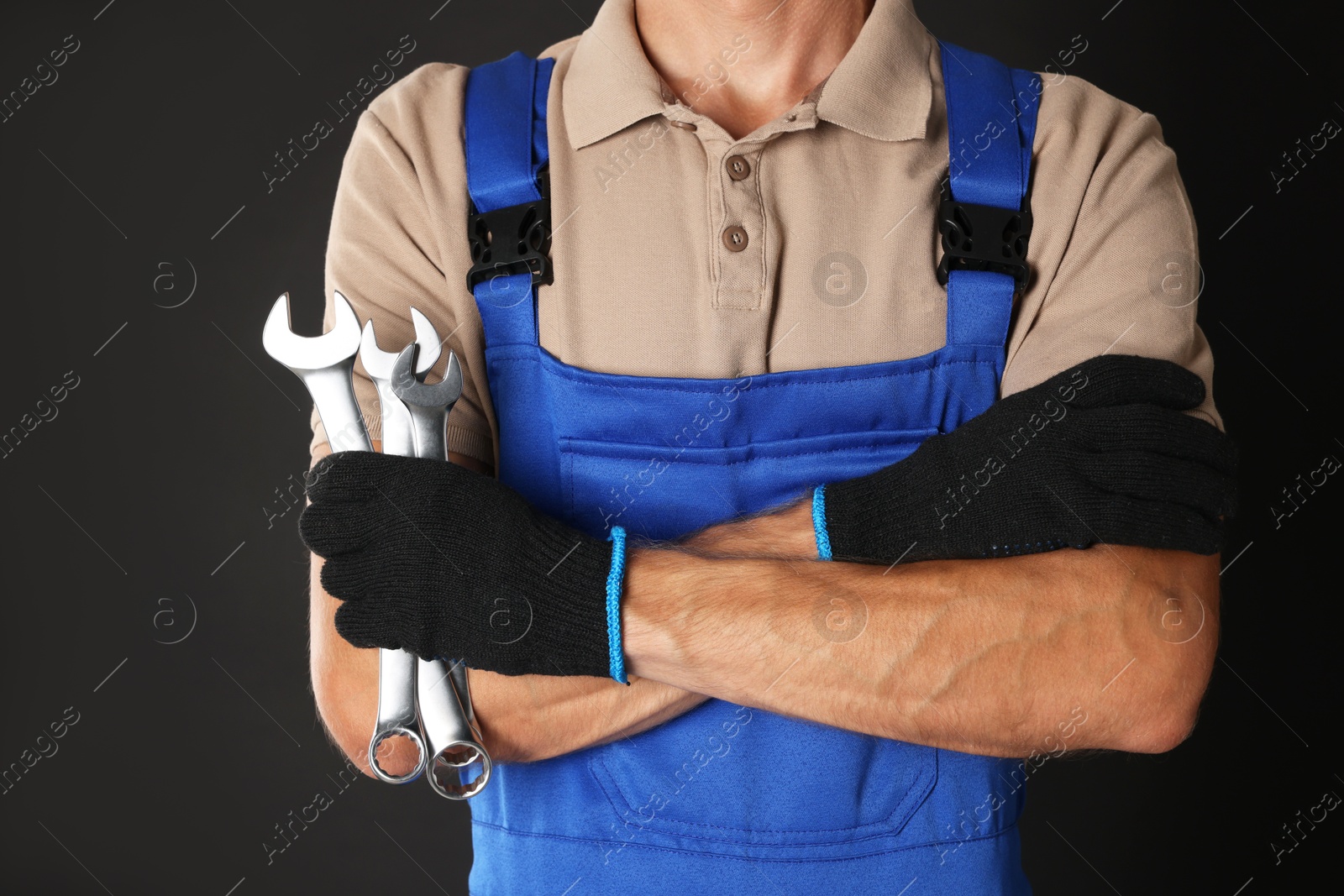 Photo of Auto mechanic with wrenches on black background, closeup