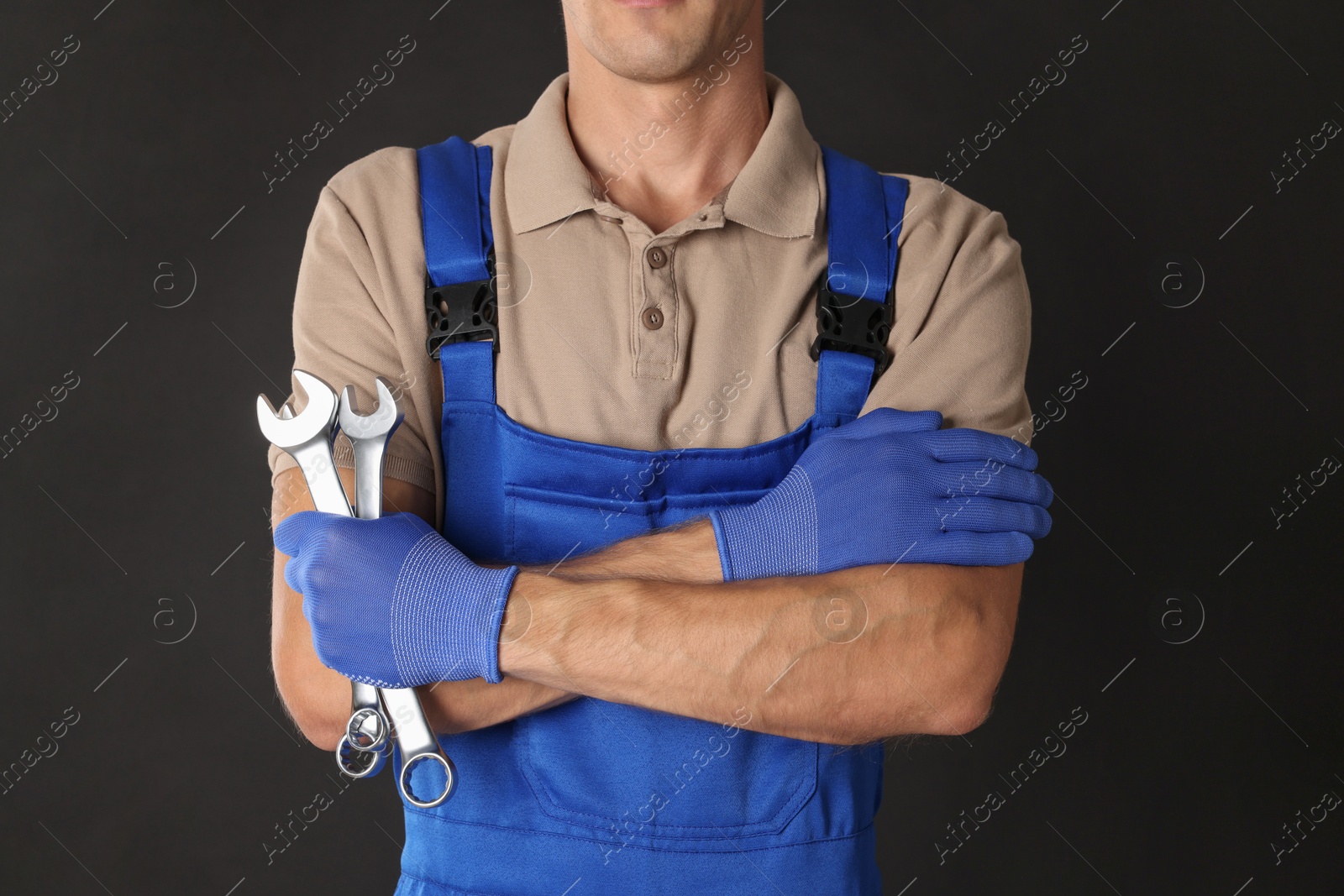 Photo of Auto mechanic with wrenches on black background, closeup