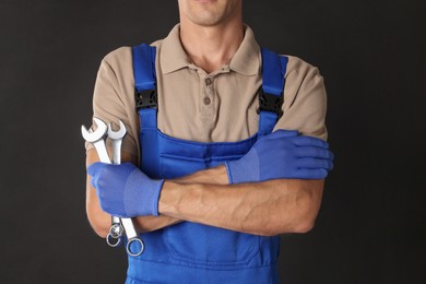 Auto mechanic with wrenches on black background, closeup