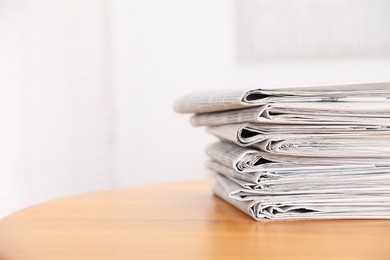 Photo of Stack of many newspapers on wooden table, space for text