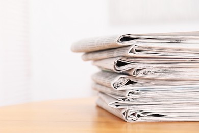 Photo of Stack of many newspapers on wooden table, space for text