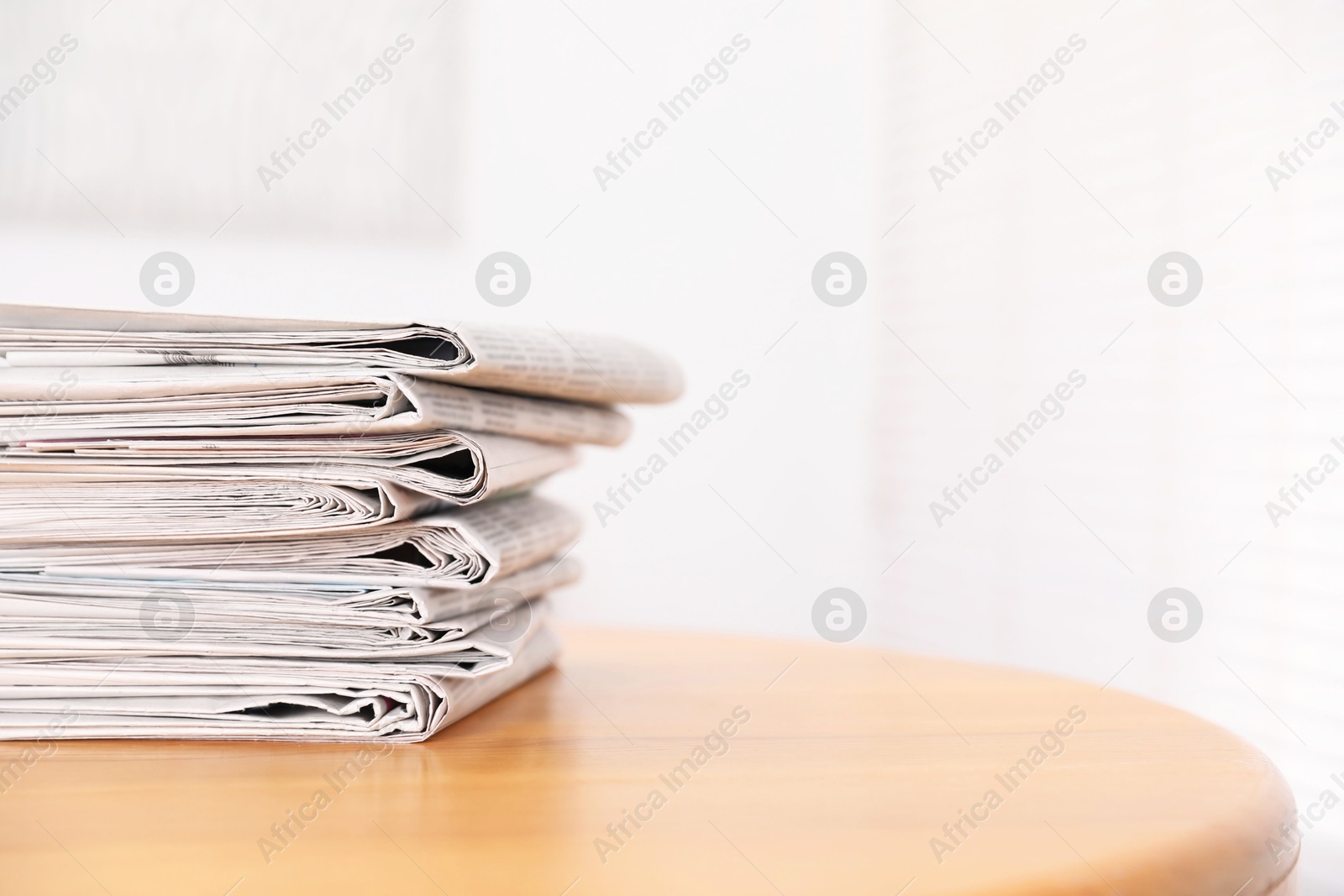 Photo of Stack of many newspapers on wooden table, space for text