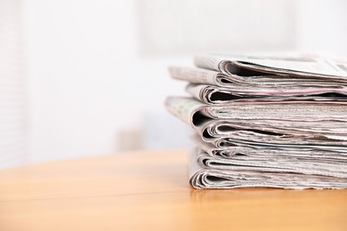 Photo of Stack of many newspapers on wooden table, space for text