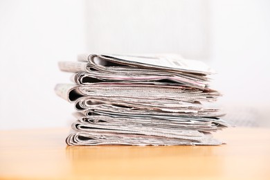 Photo of Stack of many newspapers on wooden table