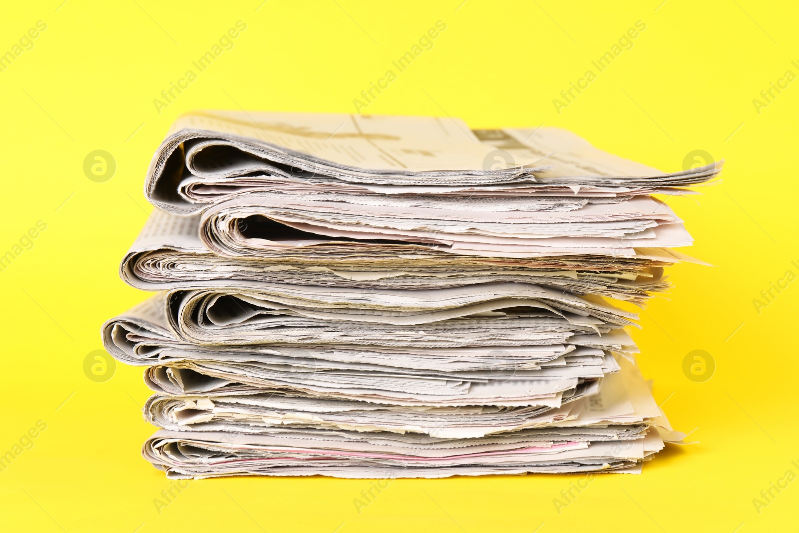 Photo of Stack of many newspapers on yellow background