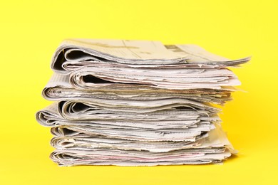 Photo of Stack of many newspapers on yellow background