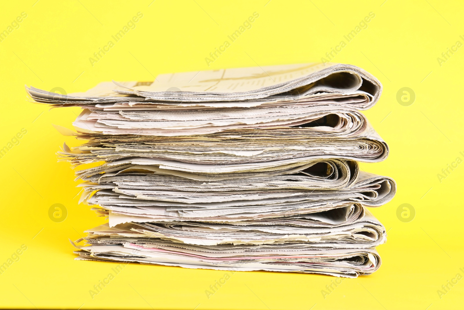 Photo of Stack of many newspapers on yellow background