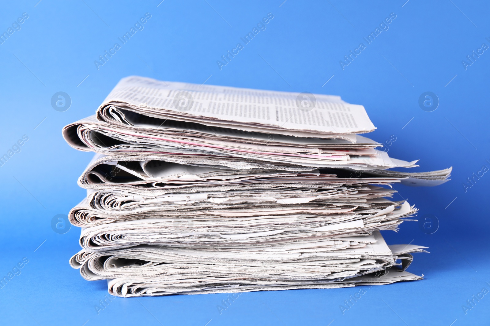 Photo of Stack of many newspapers on blue background