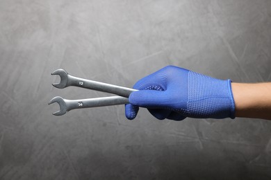 Photo of Auto mechanic with wrenches on grey background, closeup