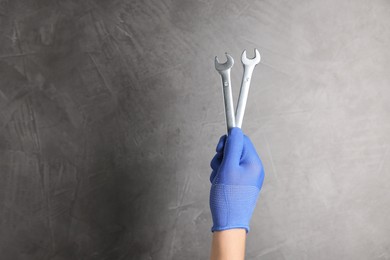 Photo of Auto mechanic with wrenches on grey background, closeup. Space for text