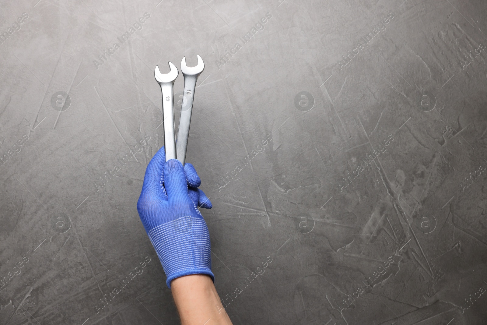 Photo of Auto mechanic with wrenches on grey textured background, closeup. Space for text