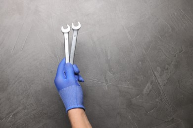 Auto mechanic with wrenches on grey textured background, closeup. Space for text