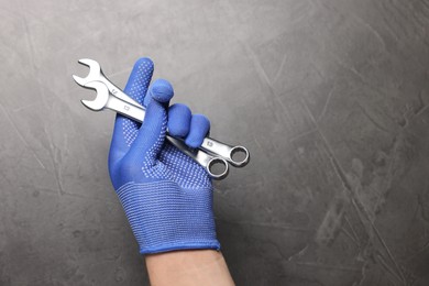 Auto mechanic with wrenches on grey background, closeup. Space for text