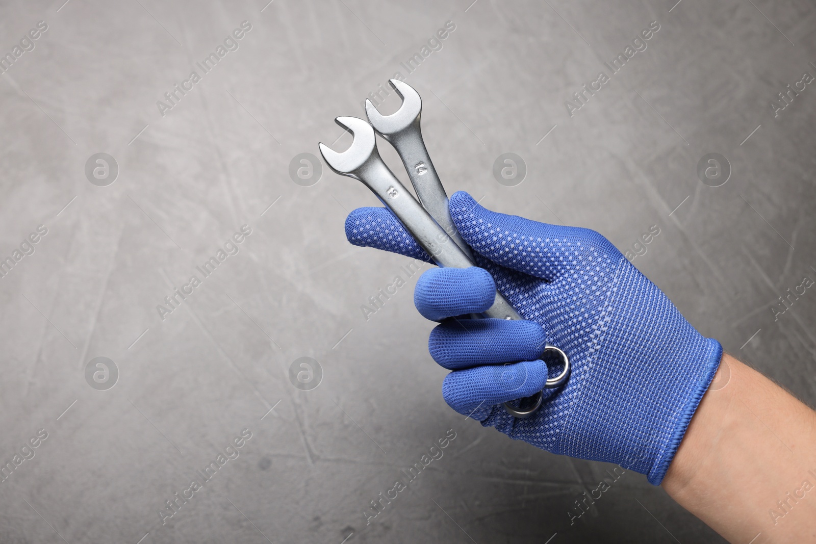 Photo of Auto mechanic with wrenches on grey background, closeup. Space for text