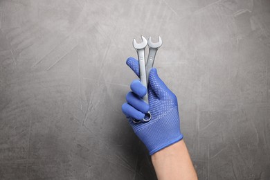 Auto mechanic with wrenches on grey textured background, closeup