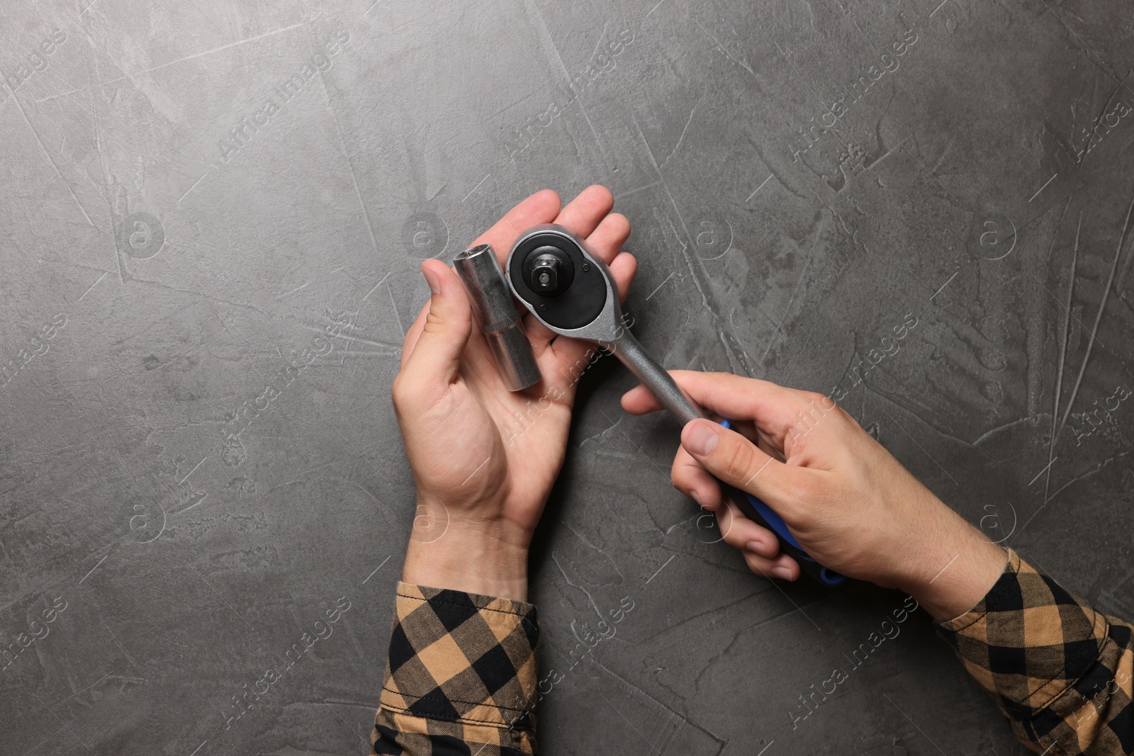 Photo of Auto mechanic with torque wrench at grey textured table, top view