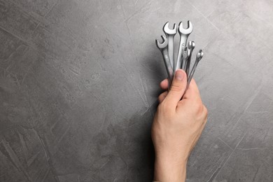 Photo of Auto mechanic with wrenches at grey textured table, top view. Space for text