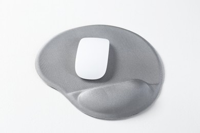 Photo of Mouse and mousepad with arm rest on white table, closeup