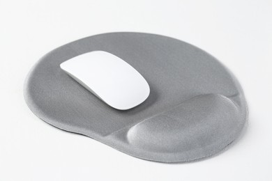 Photo of Mouse and mousepad with arm rest on white table, closeup