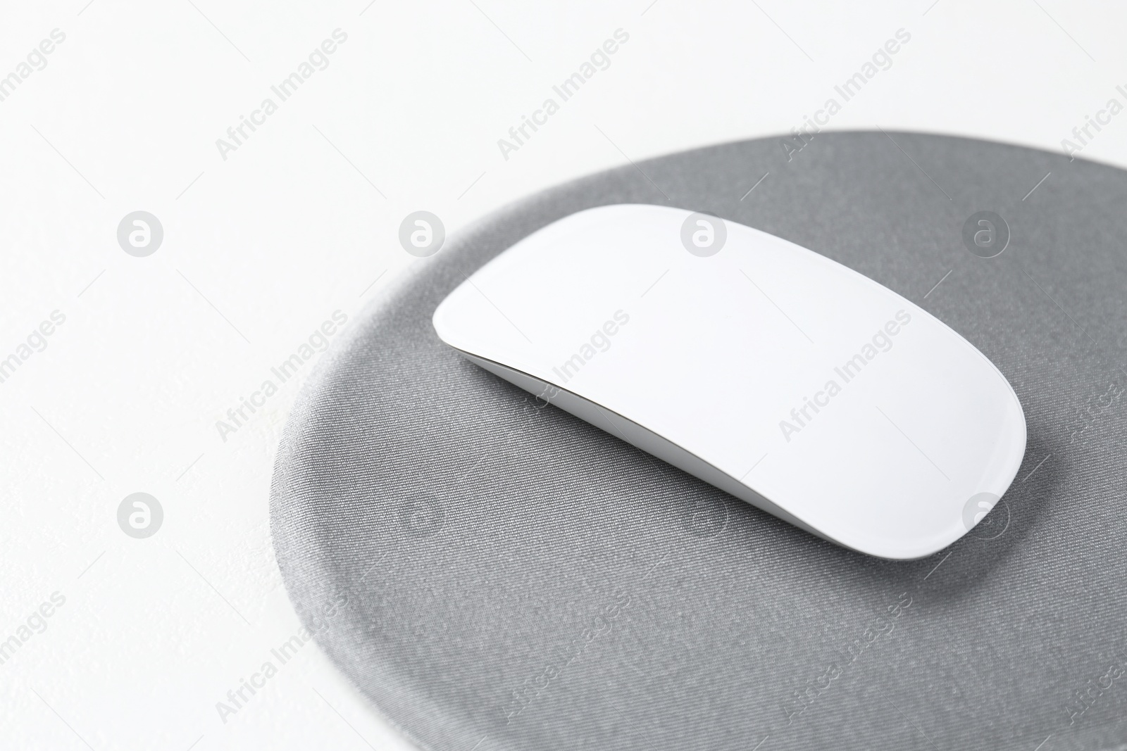 Photo of Mouse and mousepad on white table, closeup