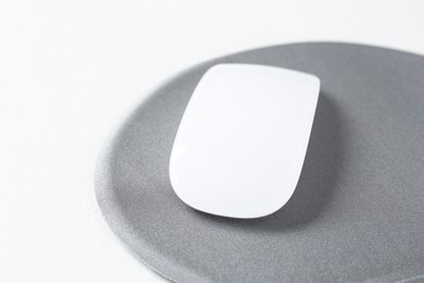 Photo of Mouse and mousepad on white table, closeup