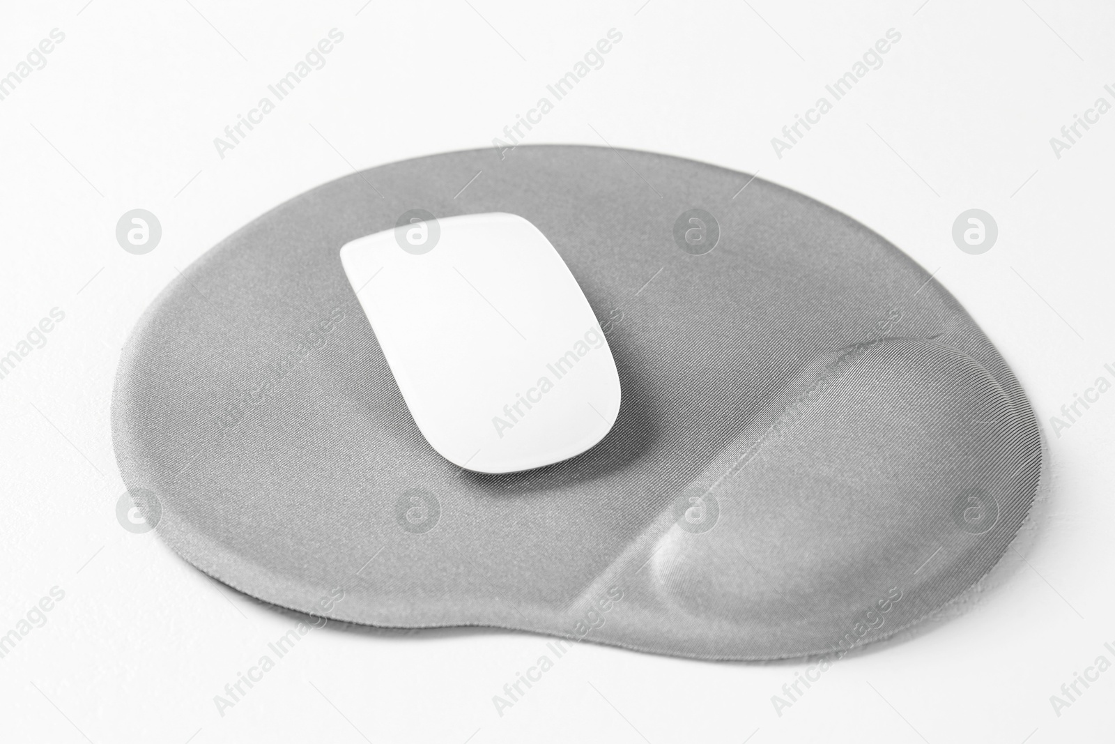 Photo of Mouse and mousepad with arm rest on white table, closeup