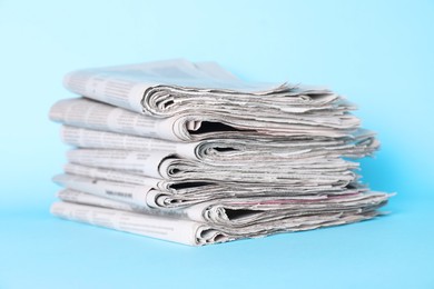 Photo of Stack of newspapers on light blue background