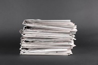 Stack of many newspapers on grey background