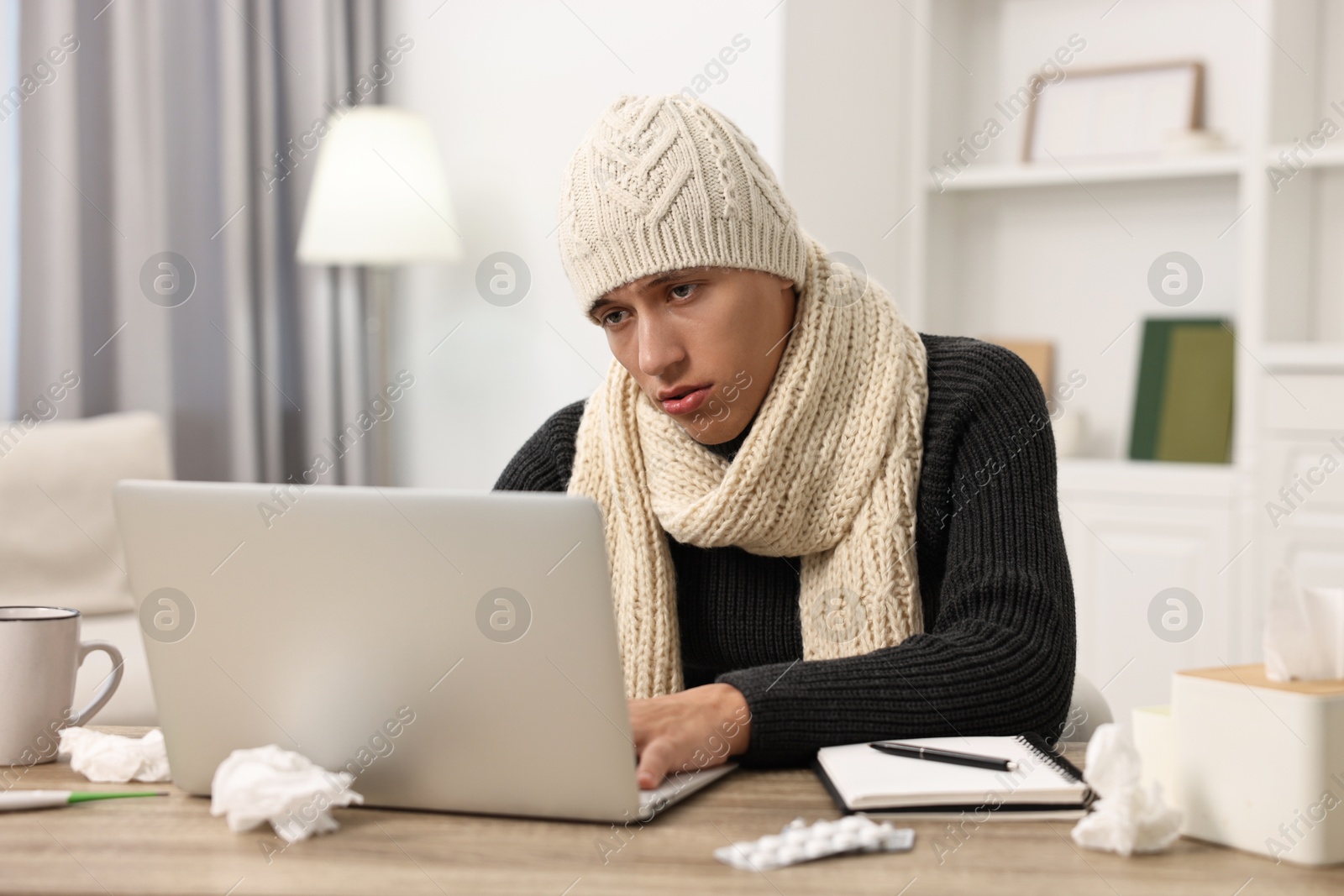 Photo of Cold symptom. Young man suffering from fever at desk indoors