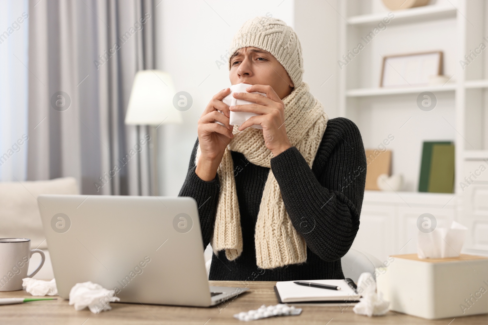 Photo of Cold symptom. Young man with runny nose at home