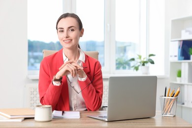 Photo of Portrait of smiling businesswoman at table in office