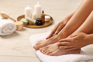 Photo of Woman touching her smooth feet on floor, closeup. Body care