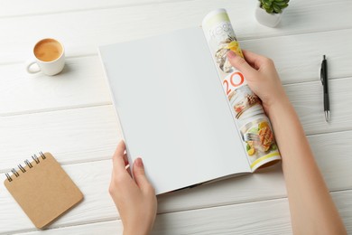 Photo of Woman reading magazine at white wooden table, closeup. Mockup for design