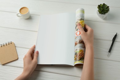 Woman reading magazine at white wooden table, closeup. Mockup for design