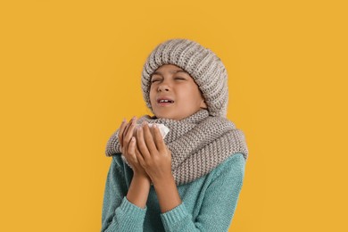 Photo of Cold symptom. Little girl with runny nose on orange background