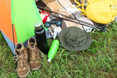 Tent and camping equipment on green grass outdoors