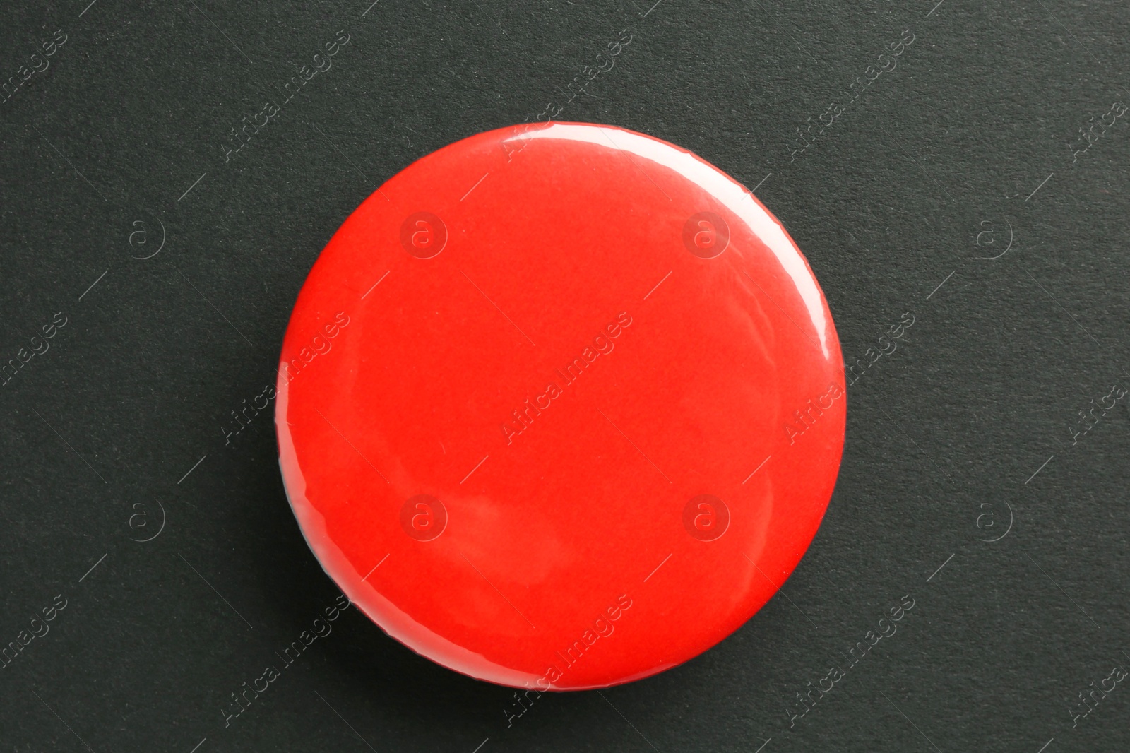 Photo of Red button badge on black background, top view. Mockup for design