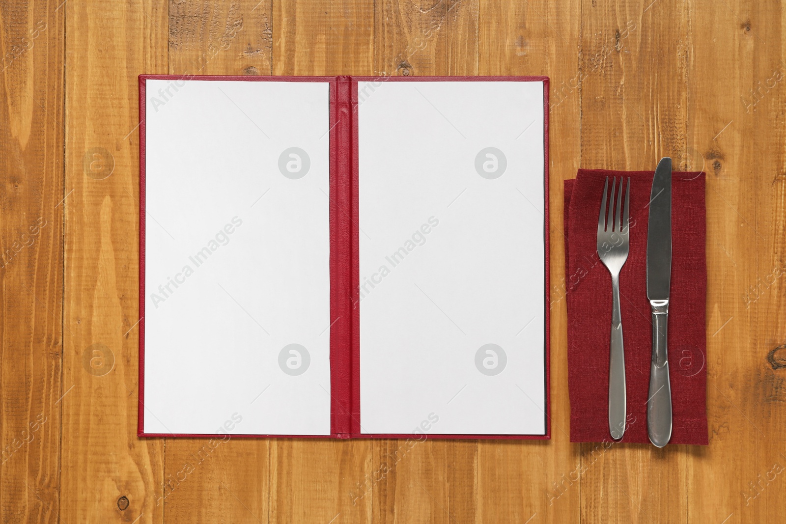 Photo of Hardcover notebook with blank sheets for menu design and cutlery on wooden table, flat lay