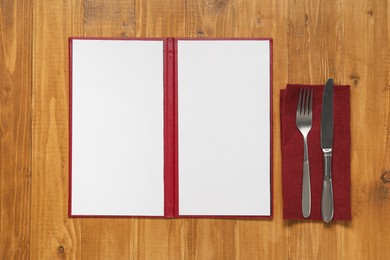 Photo of Hardcover notebook with blank sheets for menu design and cutlery on wooden table, flat lay