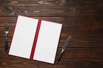 Photo of Hardcover notebook with blank sheets for menu design and cutlery on wooden table, flat lay. Space for text