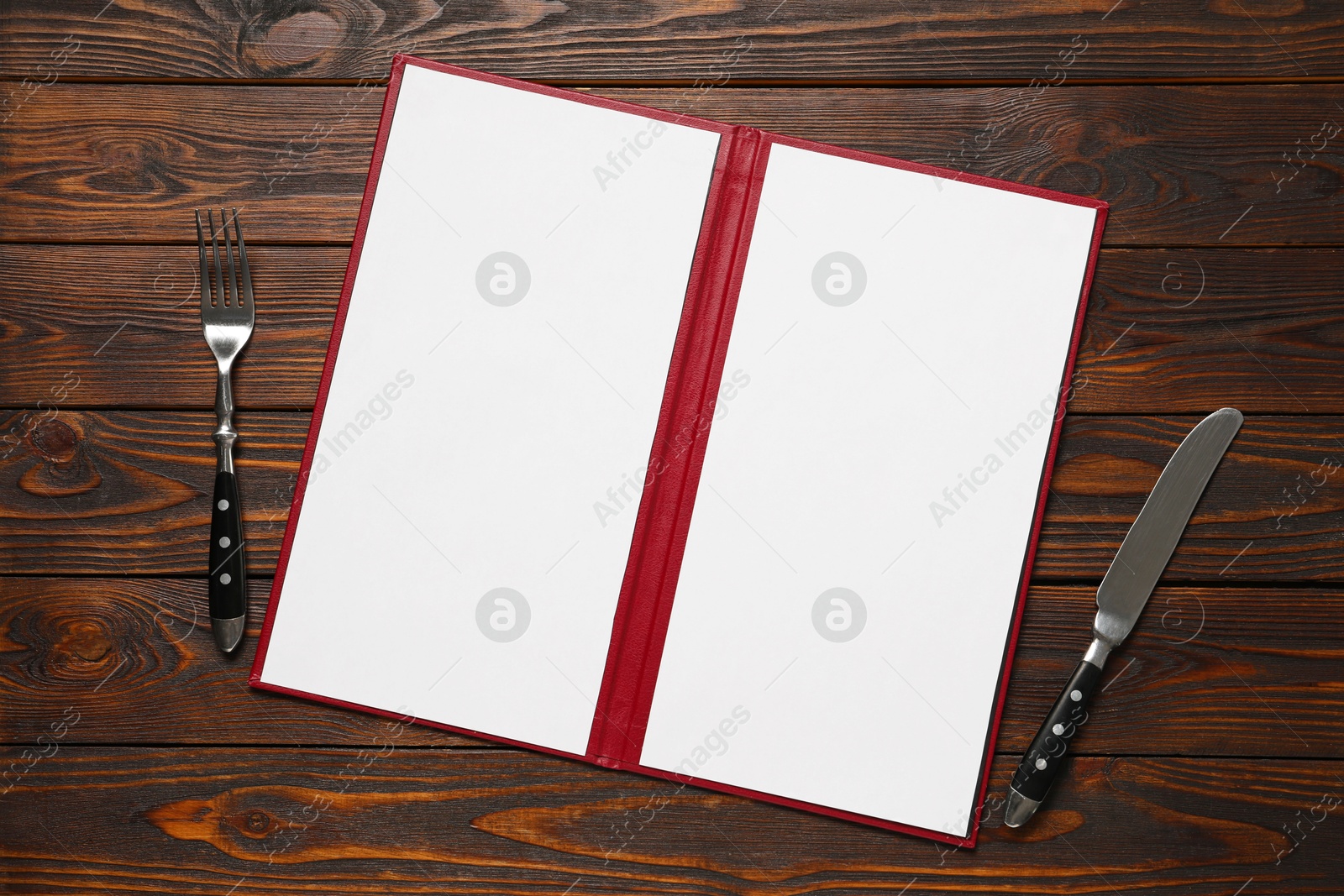 Photo of Hardcover notebook with blank sheets for menu design and cutlery on wooden table, flat lay