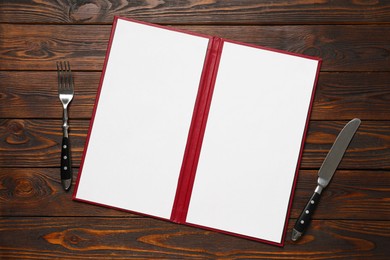 Photo of Hardcover notebook with blank sheets for menu design and cutlery on wooden table, flat lay