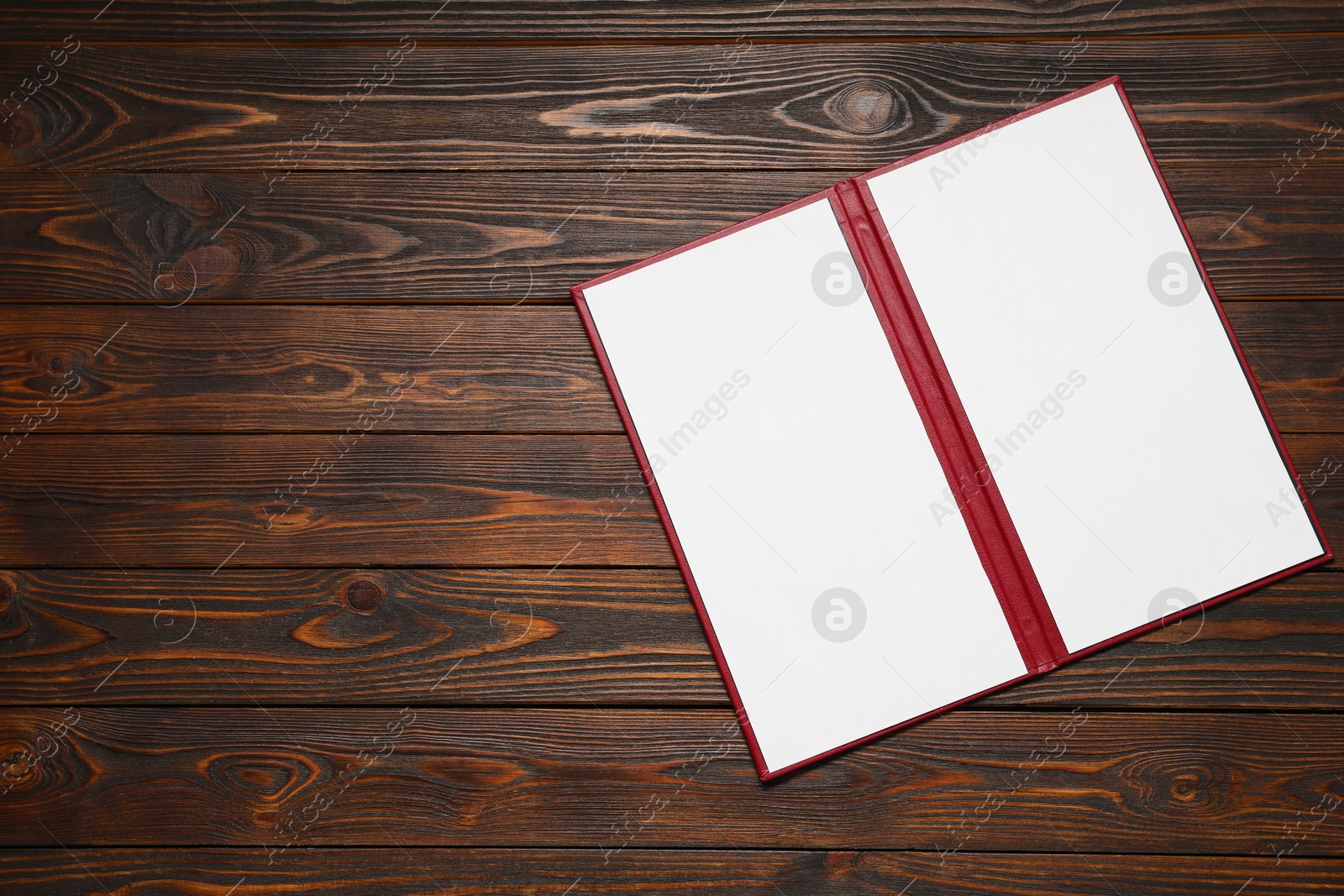 Photo of Hardcover notebook with blank sheets on wooden table, top view. Mockup for design