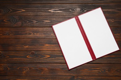 Photo of Hardcover notebook with blank sheets on wooden table, top view. Mockup for design