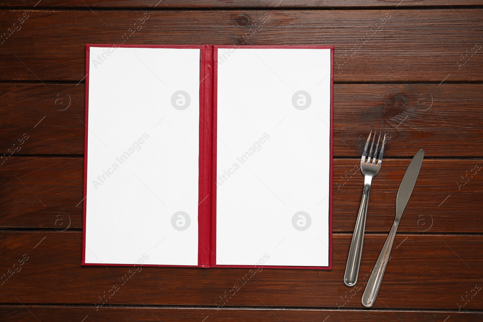 Photo of Hardcover notebook with blank sheets for menu design and cutlery on wooden table, flat lay